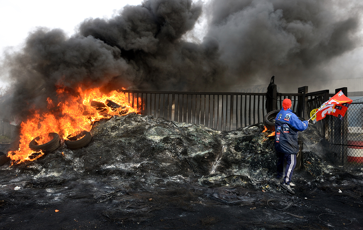 Un employé (ouvrier) de l'entreprise Goodyear à Amiens se tient sur un tas de cendres, le 5 décembre 2013, après l'annonce de la fermeture de l'usine