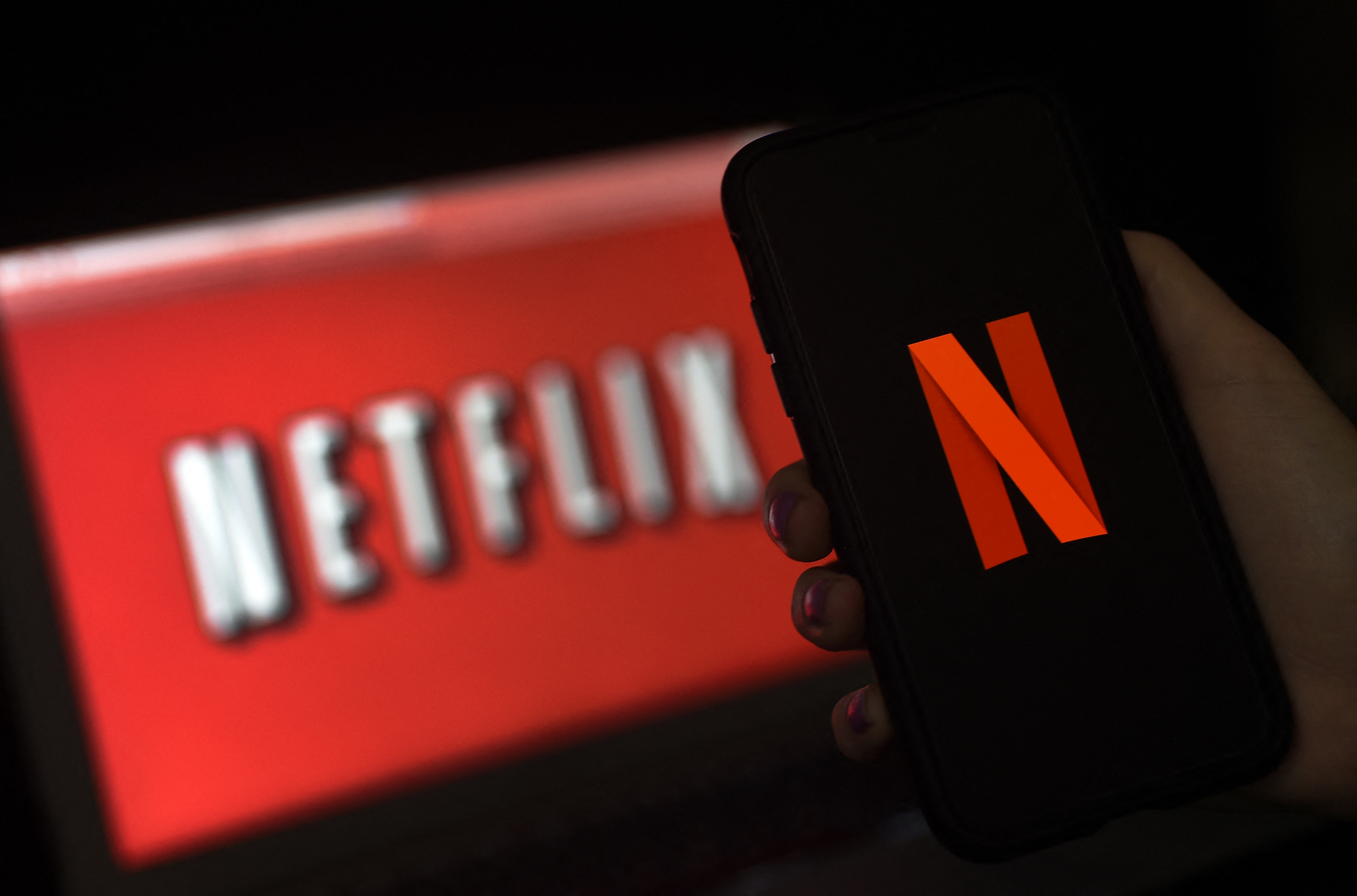 Affichage du logo Netflix sur un écran d'ordinateur et de smartphone.