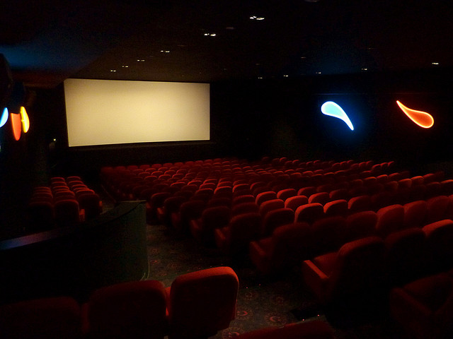 Photographie d'une salle de cinéma aux fauteuils rouges